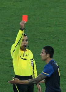 A referee hands out a red card during the World Cup