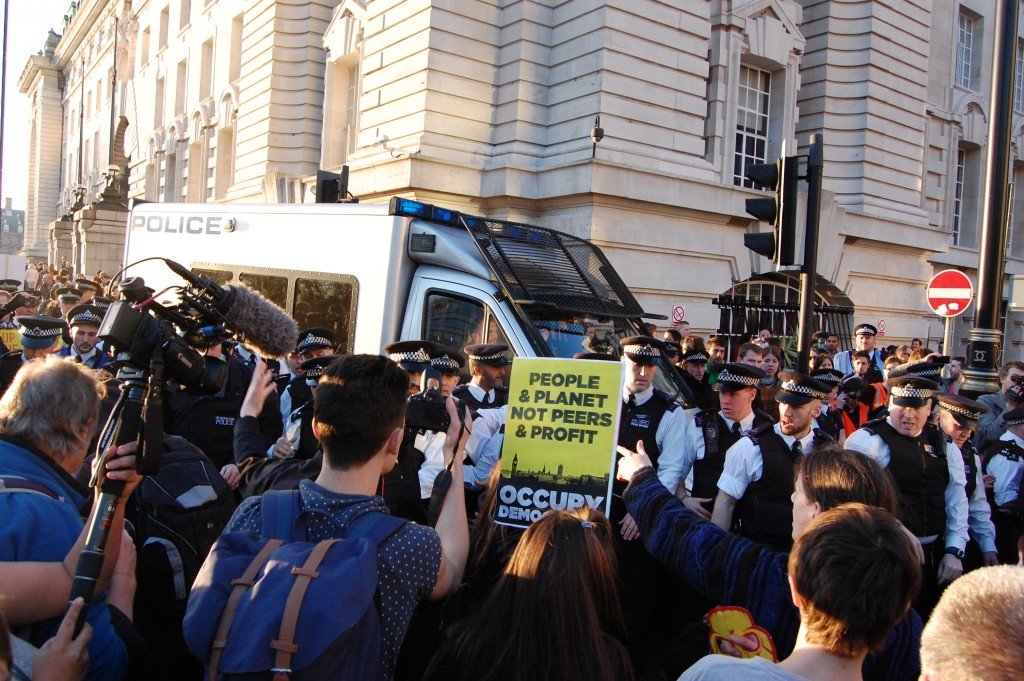 Policemen protect their van during the altercation with protesters. (Emilie Herman)